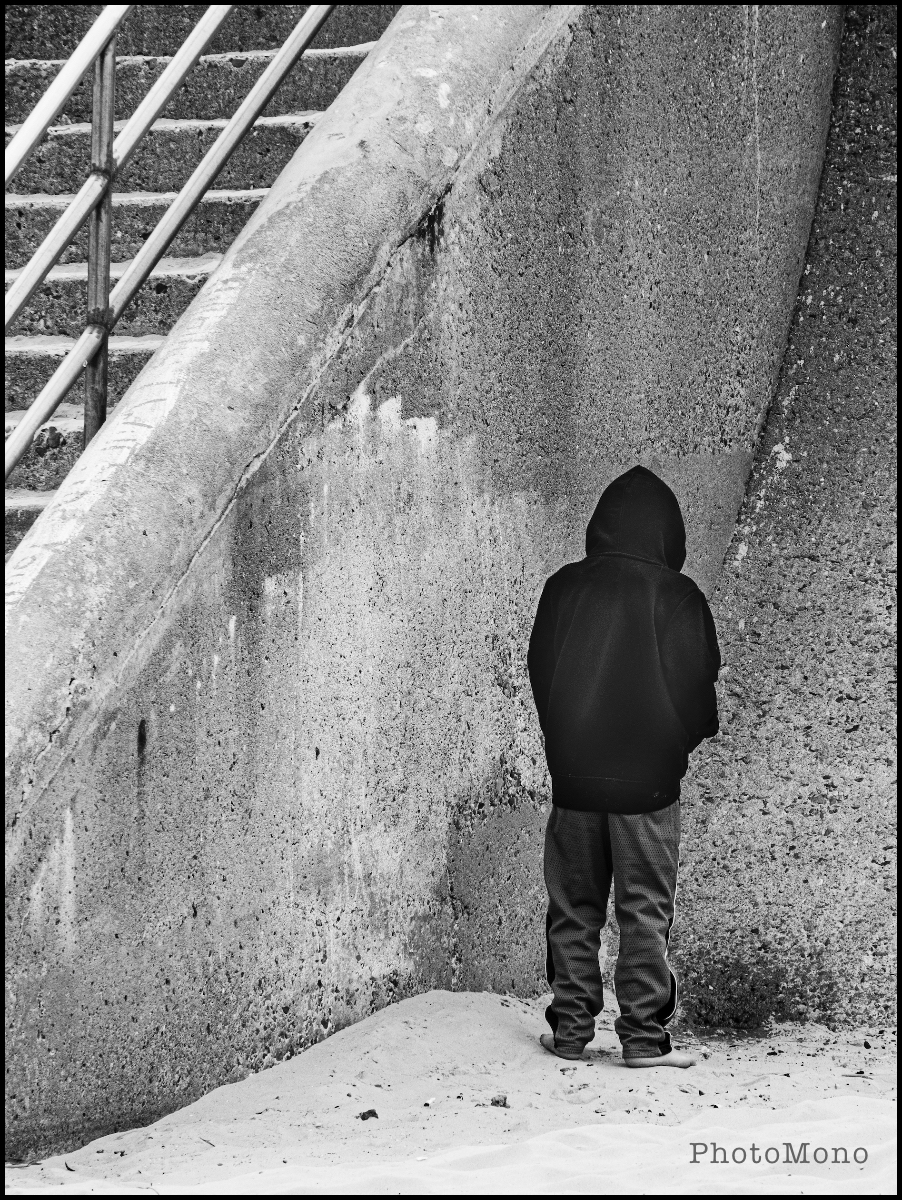 Young boy peeing against wall